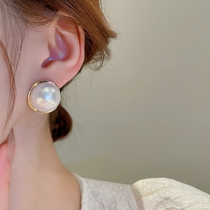Macro shot of a vintage French-style large pearl stud earring with golden metallic border