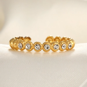 Adjustable gold plated open ring with micro-paved cubic zirconia on silk background