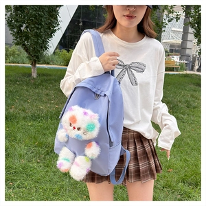 Dettaglio dello zaino in nylon viola con gatto di peluche colorato per studentesse