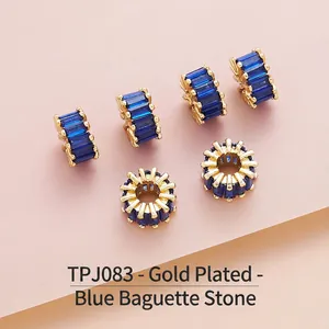 Detailed view of gold-plated brass spacer beads with baguette-cut blue zircon stones