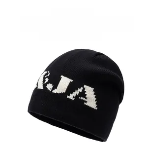 Detail of black knitted beanie featuring white JA bold letters and thick ribbed texture