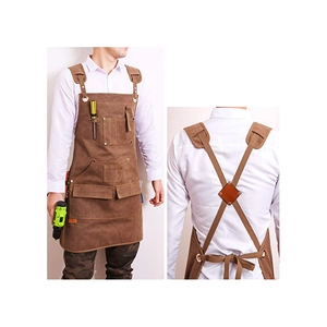 Detailed view of brown canvas apron featuring multi-pockets and cross-back straps