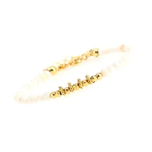 Detailed macro view of beaded bracelet with white faceted stones and gold spacers