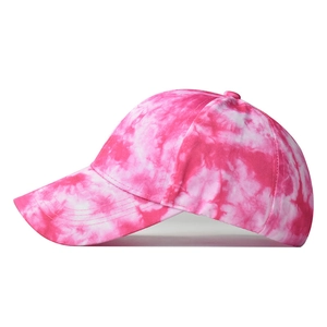 Close-up of pink and white tie-dye cotton fabric texture on a curved brim baseball cap