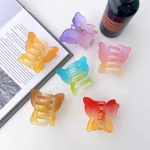 Matte butterfly hair claws in various gradient colors on white aesthetic background