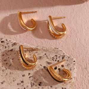 Detail of 18K gold plated U-shaped earrings with black white enamel and micro rhinestones