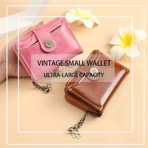 Detail of vintage small wallet featuring clover pendant zipper and floral snap button closure