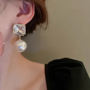 Elegant square crystal and round pearl drop earrings on model for a stylish look