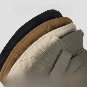 Detail of short brim nylon bucket hat with side snap buttons and multiple stitching