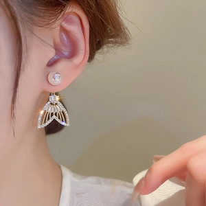 Élégantes boucles d'oreilles en nacre et zircon en forme de queue de poisson sur modèle
