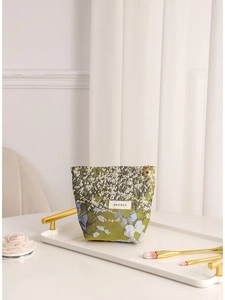 Elegant jacquard floral cosmetic bag displayed on a white tray with gold accents