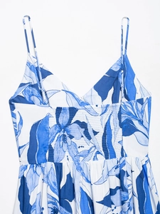 Detail of blue and white print dress featuring adjustable straps and elastic ruched back