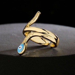 18K gold snake ring with blue evil eye detail on black stone pedestal display