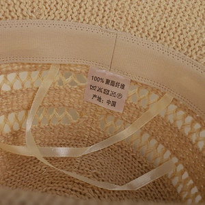 Detail of beige sun hat interior with 100% polyester weave and adjustable satin ribbon