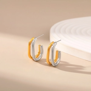 Minimalist C-shape two-tone 18K gold plated copper earrings on an elegant pedestal