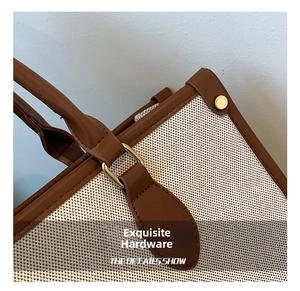 Detailansicht der Canvas-Tasche mit braunem Lederbesatz und goldenen Metallbeschlägen