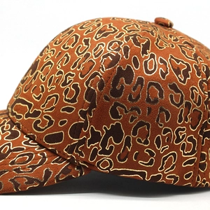 Close-up of leopard print baseball cap with gold embroidery thread and velvet texture