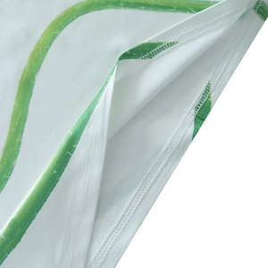 Detail showing high-quality stitching and green floral print on white summer dress fabric