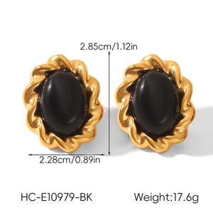 Detail view of gold twisted rope earrings with black oval stones and size dimensions