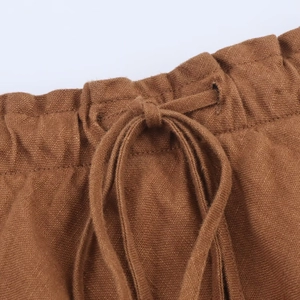 Detailed macro view of brown linen dress waist with elastic waistband and drawstring