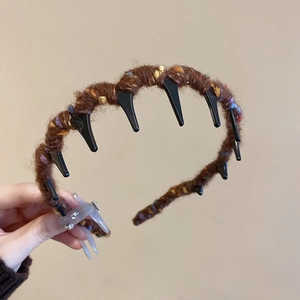 Detail of brown knitted wavy headband with anti-slip teeth showing texture and material