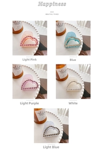 Close-up of heart-shaped hair claws with rhinestones in five soft pastel colors