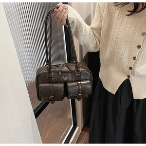 Detail of vintage brown leather Boston bag with two front pockets and gold PANTOR logo
