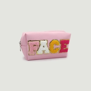 Detail of pink PU leather makeup bag featuring colorful chenille FACE letter patches