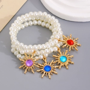 Multilayer faux pearl bracelet featuring vintage sun pendants with colorful gemstones