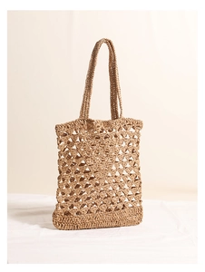 Detailed view of khaki straw woven tote bag featuring hollow mesh geometric texture