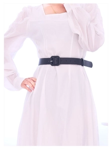 Detail of a minimalist black leather belt with a square buckle on a white dress