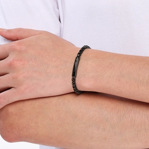 Détail d'un bracelet minimaliste en acier inoxydable noir avec perles au poignet