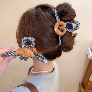 Détail de la pince à cheveux croissant et bretzel avec tissu à carreaux noir et blanc