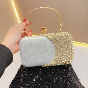 Detail of evening clutch featuring sparkling rhinestones and a gold metal ring handle
