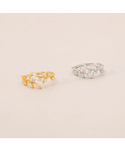 Detail of olive branch open rings in gold and silver with sparkling marquise zircons