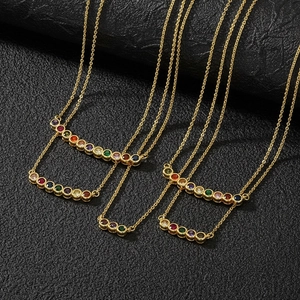 Detail of 18K gold plated necklace featuring vibrant multi-color gemstones on black leather