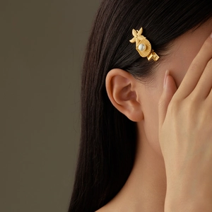 Eleganter goldener Seestern-Haarclip mit Perle, an einem Model präsentiert