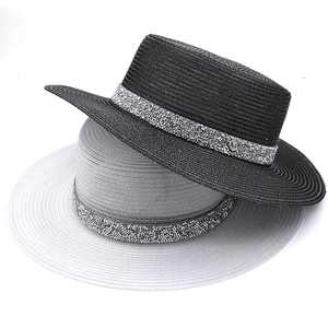 Vue détaillée des chapeaux de paille avec rubans en strass brillants et emblème M en métal