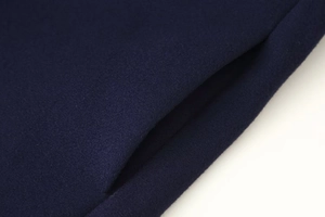 Detail der Seitentasche eines marineblauen Wollmantels mit hochwertiger Naht und Stoffstruktur