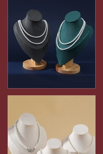 Detail of velvet jewelry bust displaying double-layered pearl necklace with orb pendant