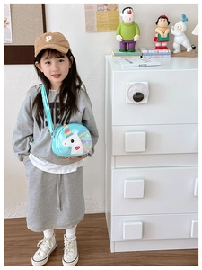 Little girl wearing a cute blue unicorn crossbody bag with rainbow details and heart pattern