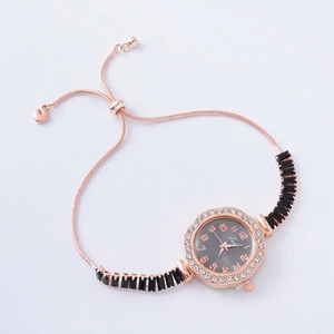 Detail of rose gold bracelet watch with rhinestone bezel and adjustable heart charm slider