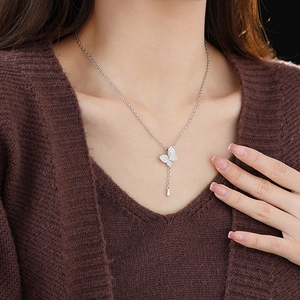 Close-up of a silver butterfly pendant necklace with sparkling zircons on a model