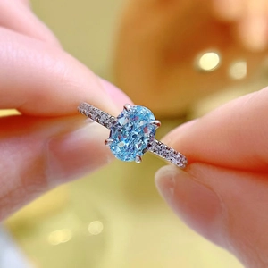 Detailed macro shot of oval aquamarine blue stone and pavé diamonds on a silver ring