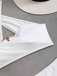 Detail view of white bikini top with gold metal rings and breathable inner lining fabric