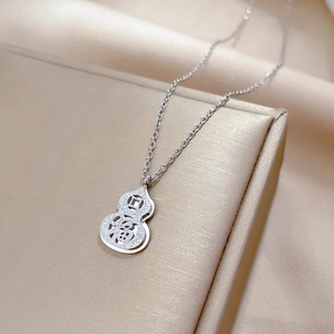 Detail of silver gourd pendant with hollowed Fù character on a delicate O-chain