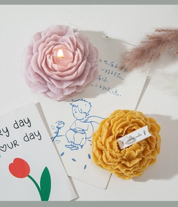 Detailed top view of realistic peony flower candles with warm lighting and soft petals