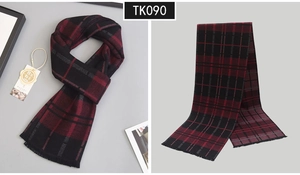 Detail view of the red and black plaid wool scarf with elegant fringe and soft texture