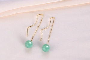 Macro detail of long S925 silver ear threads with green aventurine jade stone tassels