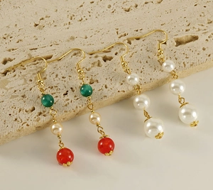 Detail view of 18k gold stainless steel earrings with pearls and agate on stone stand